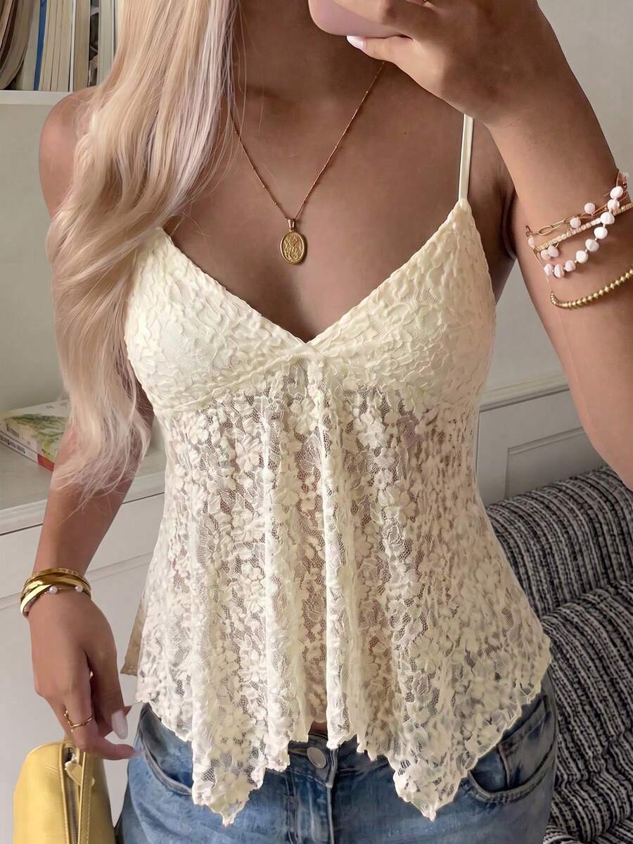 Women's white deep V-neck lace cami top featuring thin straps, semi-sheer lace fabric, and an asymmetrical hemline.