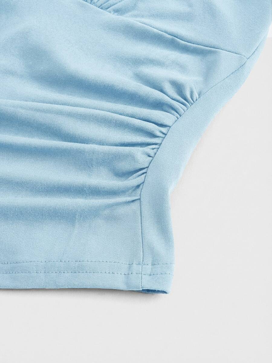 Women's halter crop tank top featuring a backless silhouette and ruched detailing in a slim fit design.
