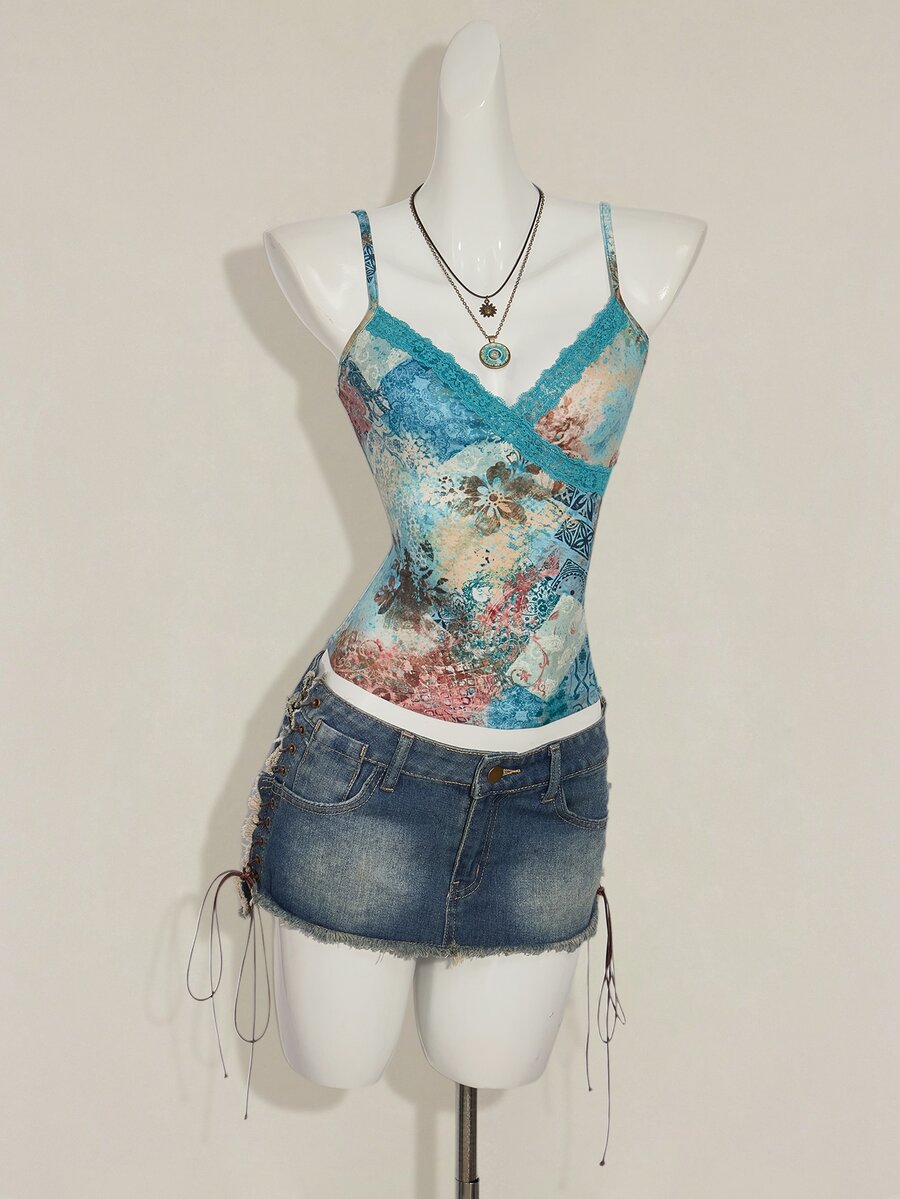 Women's blue fitted camisole top with contrast lace patchwork print, backless asymmetrical hem, and spaghetti straps.