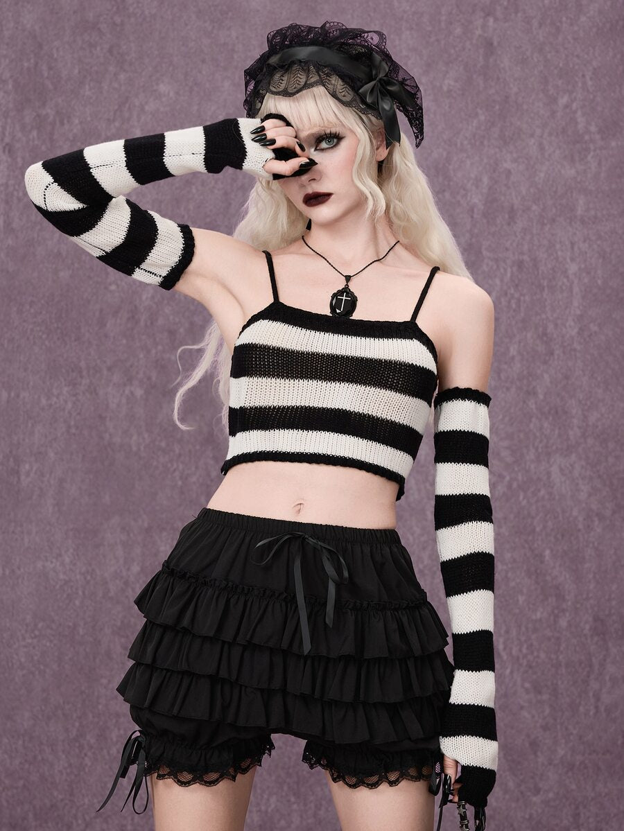 Women wearing a black and white striped camisole knit crop top with spaghetti straps and extra-long cold shoulder sleeves.
