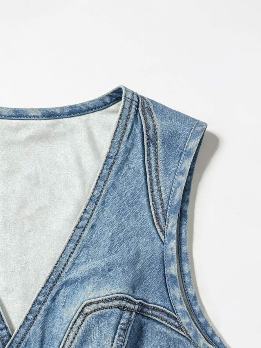 Woman wearing a blue denim print tank top featuring a button-front design, asymmetrical hem, and matching detached arm sleeves.