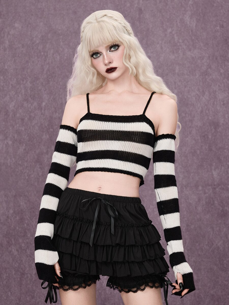 Women wearing a black and white striped camisole knit crop top with spaghetti straps and extra-long cold shoulder sleeves.