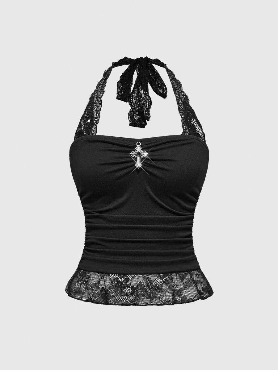 Front view of a women's black gothic Y2K halter crop top with contrast lace trim, ruched waist detail, cross accent, and tie-back backless design.