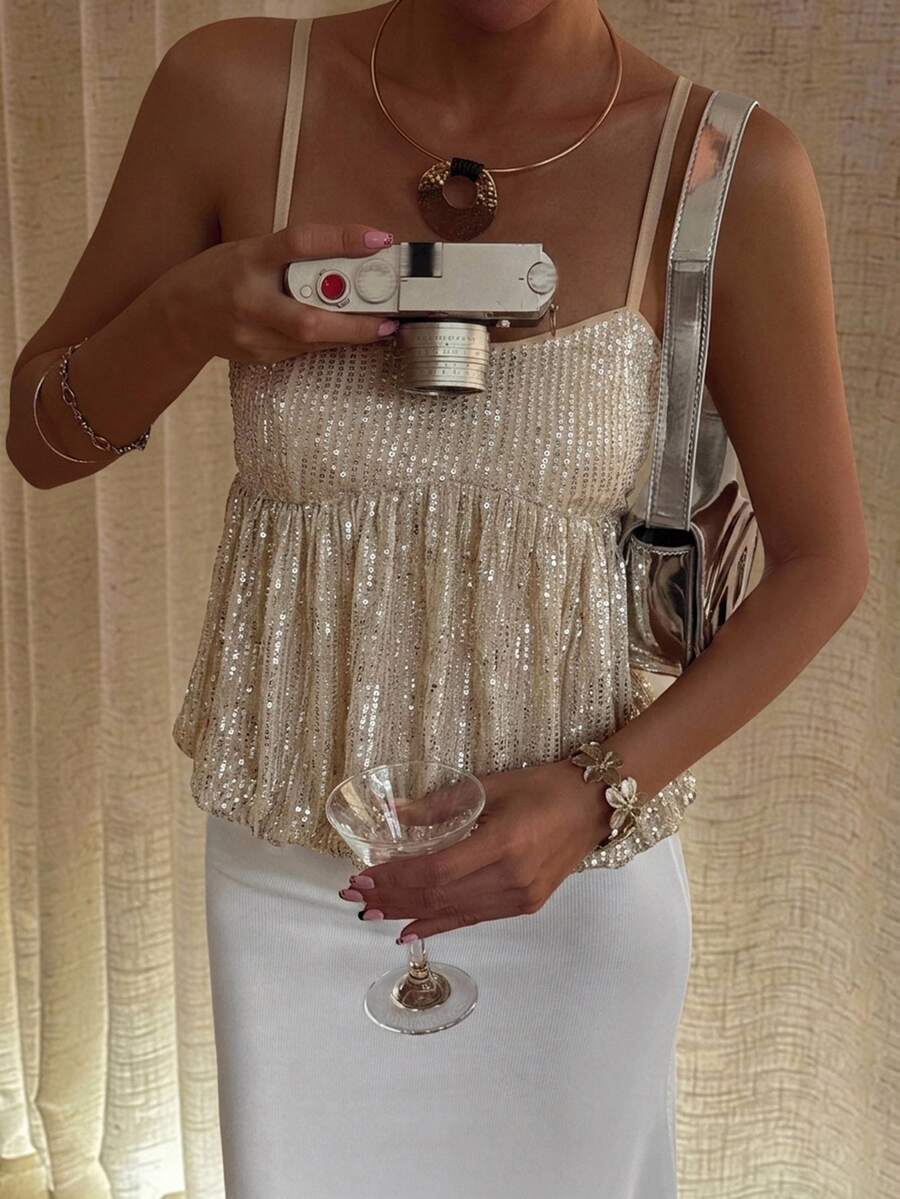 Burgundy sequin spaghetti strap cami top featuring a backless design and flared ruffle hem.