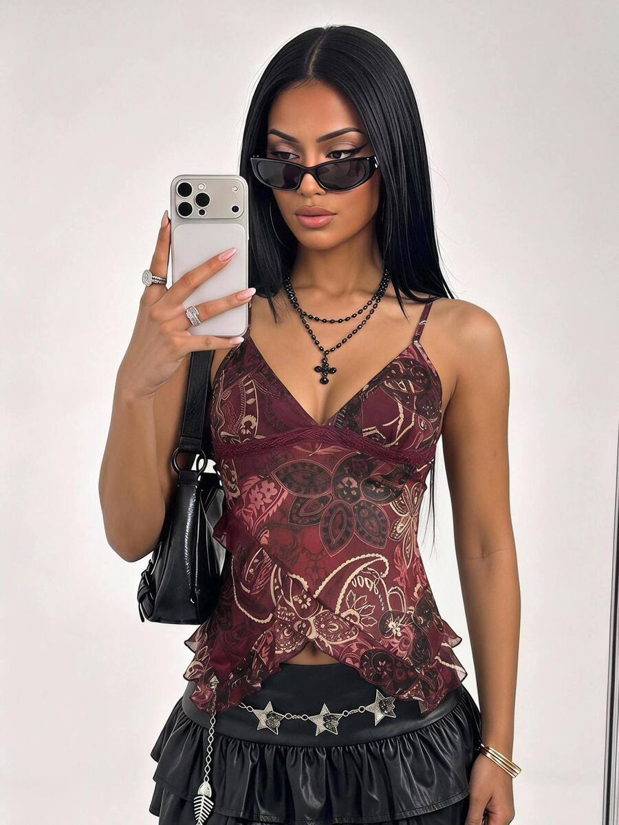 Women's burgundy floral graphic print mesh camisole top featuring an asymmetrical hem, backless cut, and spaghetti straps.