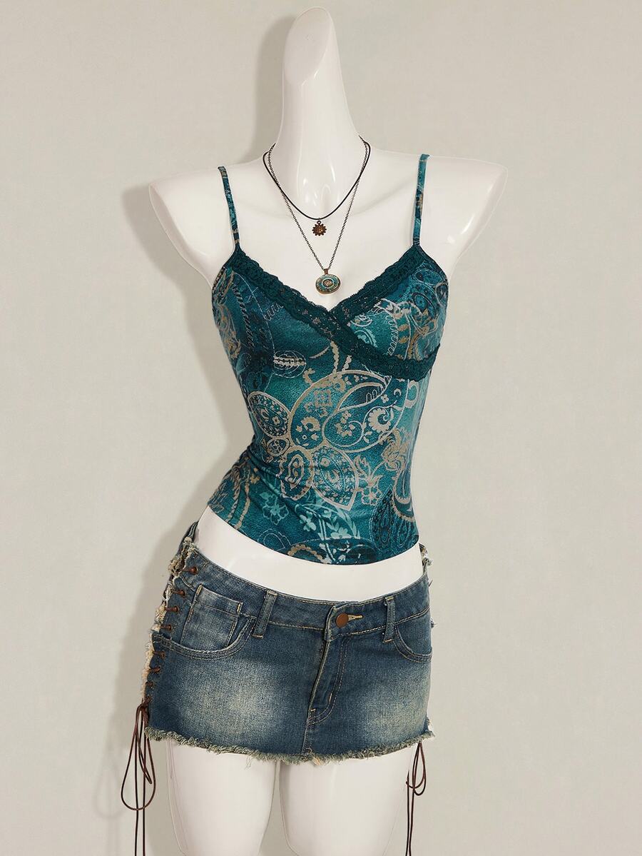 Women's blue fitted camisole top with contrast lace patchwork print, backless asymmetrical hem, and spaghetti straps.