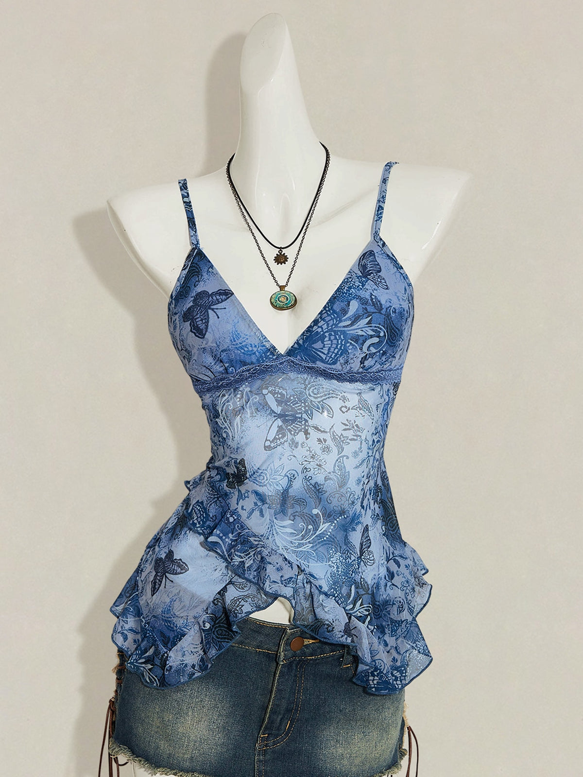 Women's burgundy floral graphic print mesh camisole top featuring an asymmetrical hem, backless cut, and spaghetti straps.