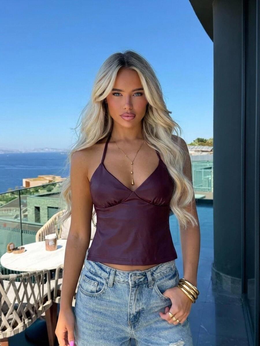 Women's black faux leather backless cami top with spaghetti straps and lace-up shirred sides.