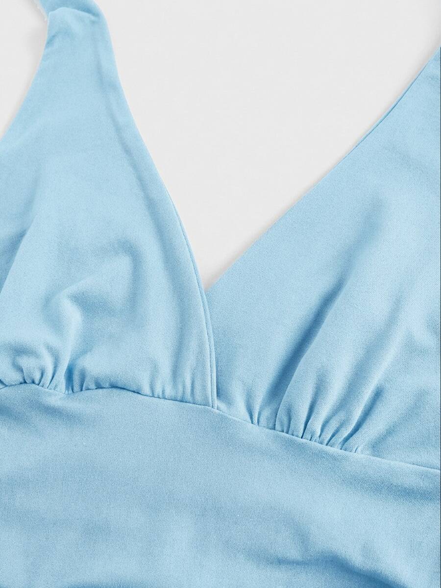 Women's halter crop tank top featuring a backless silhouette and ruched detailing in a slim fit design.