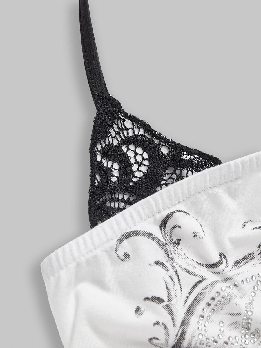 Woman wearing a black Y2K concert print 2-in-1 contrast lace halter crop top featuring a backless design with knot details.
