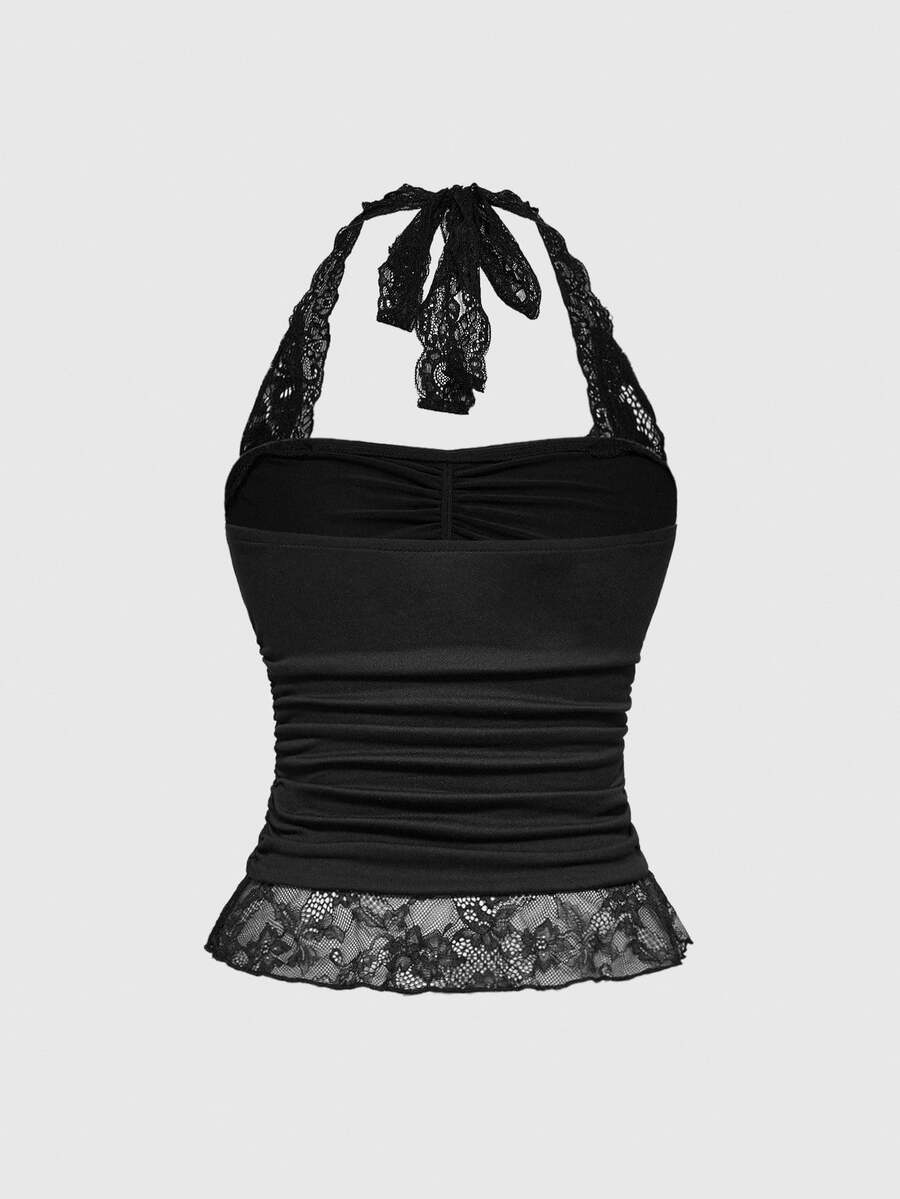 Front view of a women's black gothic Y2K halter crop top with contrast lace trim, ruched waist detail, cross accent, and tie-back backless design.