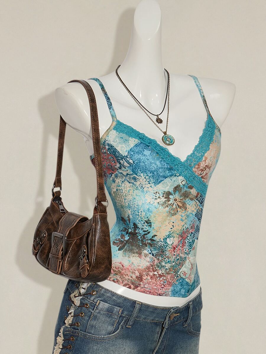 Women's blue fitted camisole top with contrast lace patchwork print, backless asymmetrical hem, and spaghetti straps.