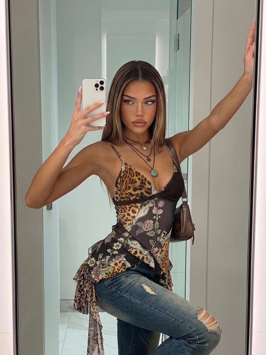 Women's burgundy floral graphic print mesh camisole top featuring an asymmetrical hem, backless cut, and spaghetti straps.