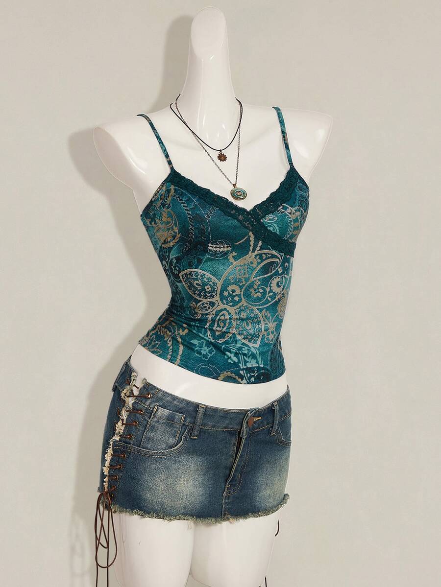 Women's blue fitted camisole top with contrast lace patchwork print, backless asymmetrical hem, and spaghetti straps.