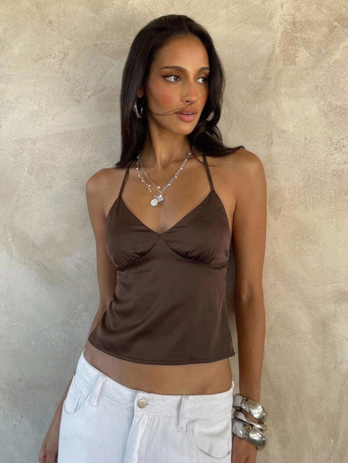Women's black faux leather backless cami top with spaghetti straps and lace-up shirred sides.